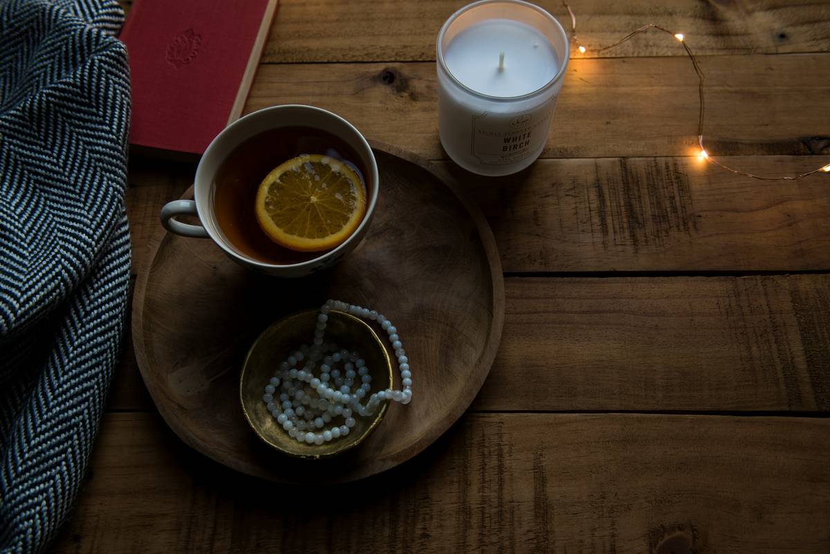 Woman relaxing in dim bedroom with journal—what can help insomnia includes wind-down routines